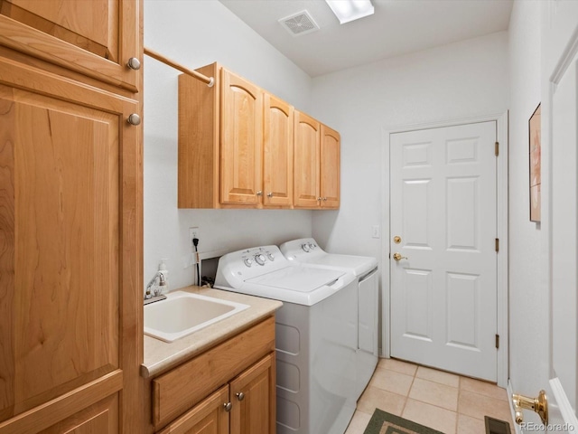 laundry room featuring visible vents, cabinet space, a sink, light tile patterned flooring, and washer and dryer