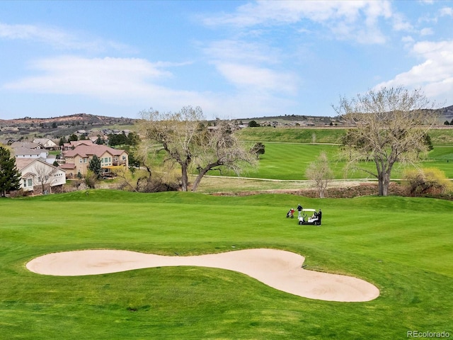 view of property's community with a lawn and golf course view