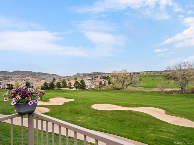 view of yard featuring view of golf course and a mountain view