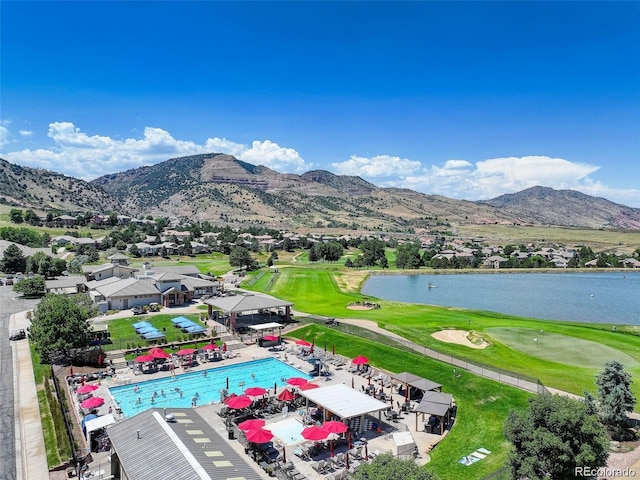 drone / aerial view with a water and mountain view, golf course view, and a residential view