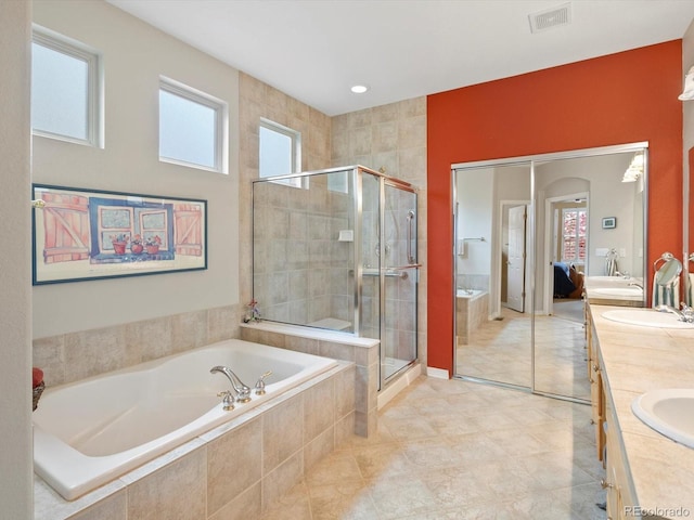 ensuite bathroom with connected bathroom, double vanity, a shower stall, visible vents, and a bath