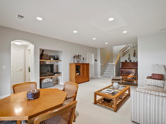 living room with stairs, light colored carpet, visible vents, and recessed lighting