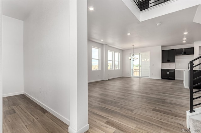 2651 E 102nd Pl, Thornton, CO 80229 - unfurnished living room featuring a chandelier, light wood-style floors, recessed lighting, and stairs