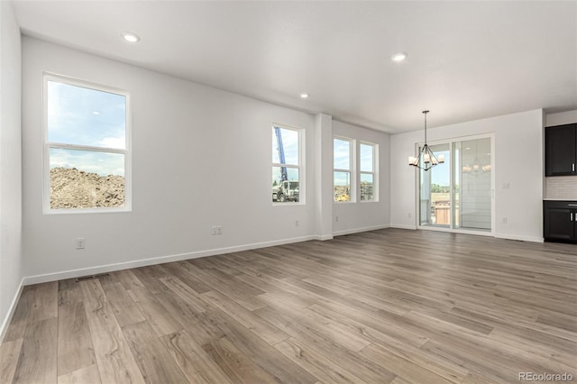 2651 E 102nd Pl, Thornton, CO 80229 - unfurnished living room with a chandelier, light wood-style flooring, and recessed lighting
