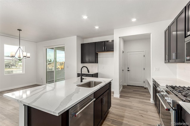 2651 E 102nd Pl, Thornton, CO 80229 - kitchen featuring stainless steel appliances, a chandelier, light wood finished floors, light stone counters, and recessed lighting