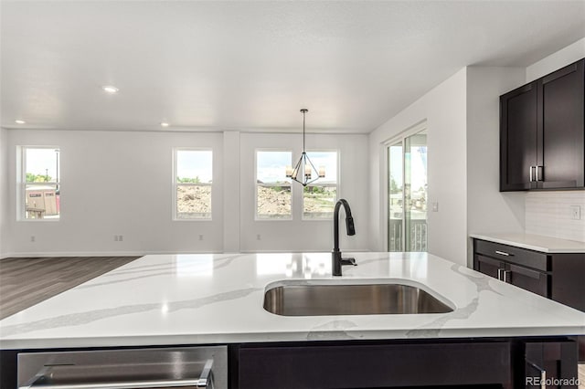 2651 E 102nd Pl, Thornton, CO 80229 - kitchen featuring light stone countertops, plenty of natural light, wood finished floors, a kitchen island with sink, and recessed lighting
