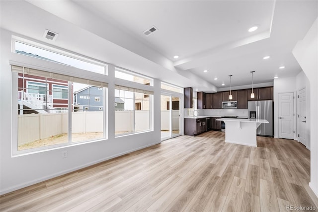 kitchen with visible vents, dark brown cabinetry, light countertops, light wood-style flooring, and stainless steel appliances