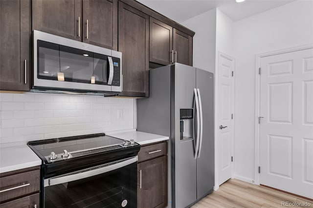 kitchen featuring stainless steel appliances, tasteful backsplash, dark brown cabinets, and light countertops