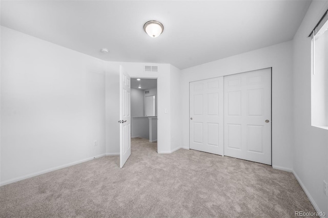 unfurnished bedroom featuring carpet, visible vents, a closet, and baseboards