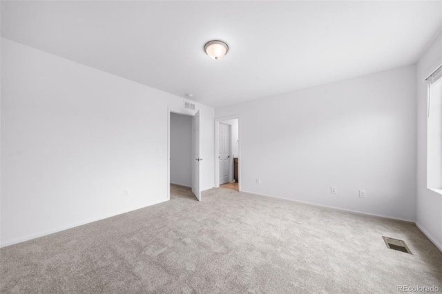 empty room featuring visible vents and light colored carpet