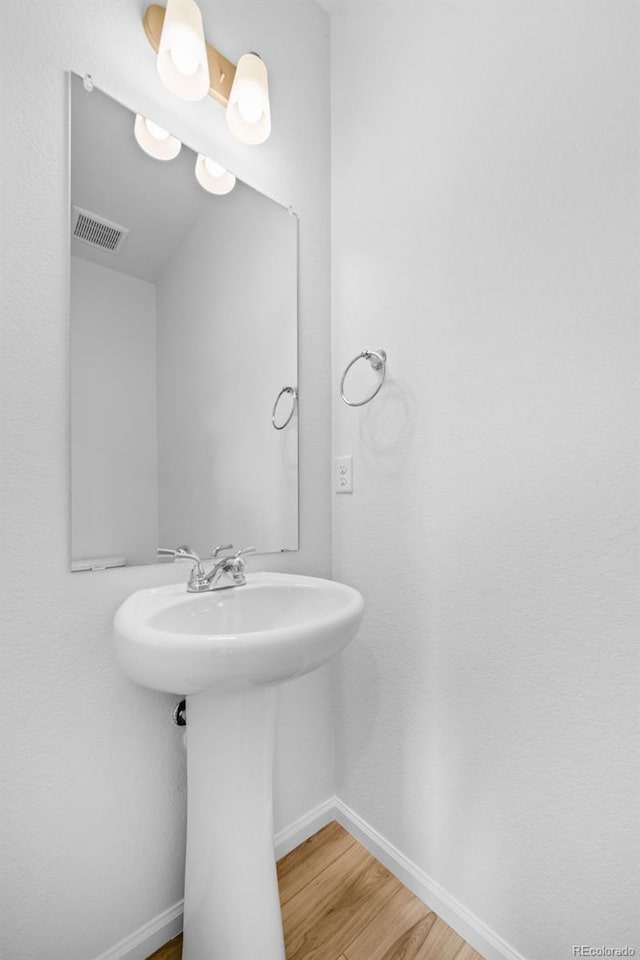 bathroom with visible vents, baseboards, and wood finished floors