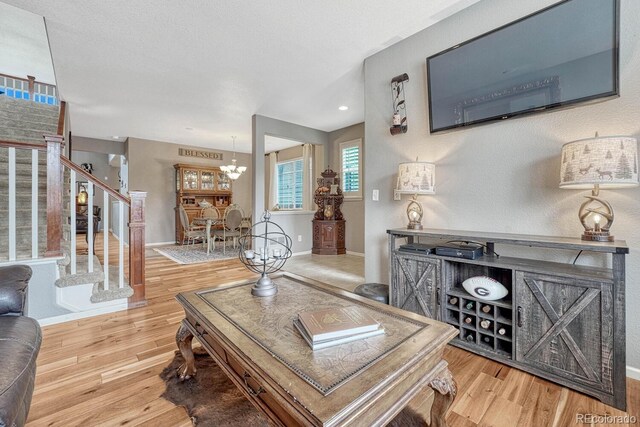 living room with hardwood / wood-style floors and an inviting chandelier