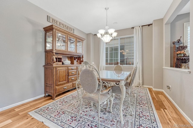 dining space featuring light hardwood / wood-style flooring and an inviting chandelier