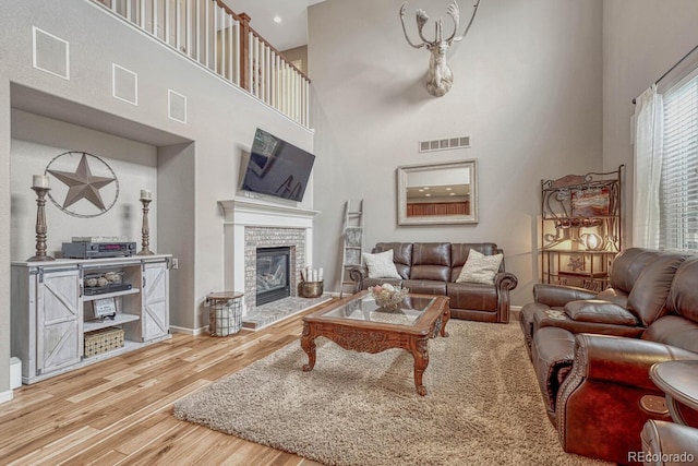 living room with hardwood / wood-style flooring and a towering ceiling