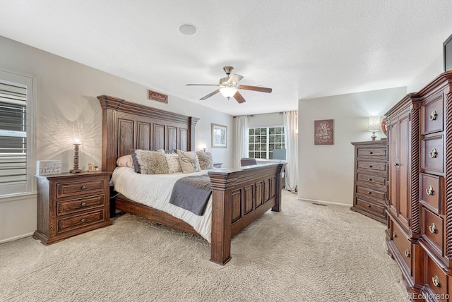 bedroom featuring ceiling fan, a textured ceiling, and light colored carpet