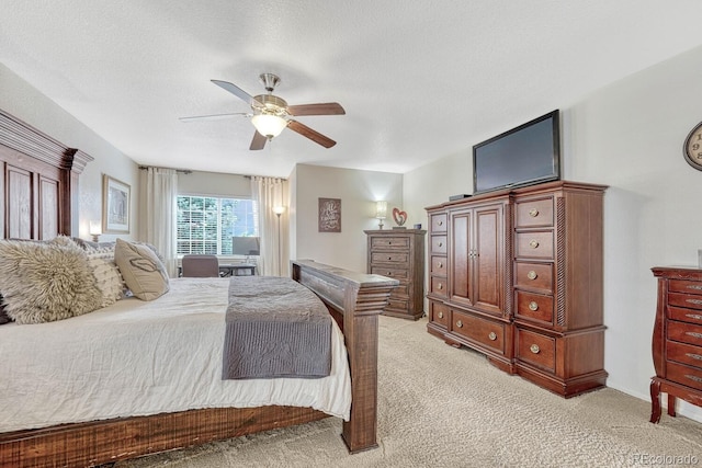 bedroom featuring ceiling fan, a textured ceiling, and light carpet