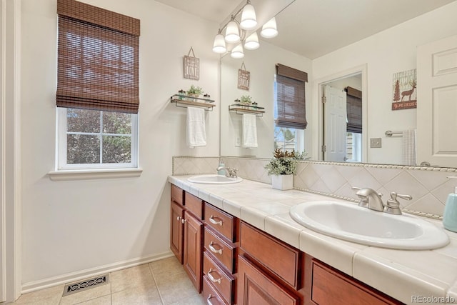 bathroom with tasteful backsplash, dual bowl vanity, and tile patterned flooring