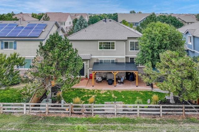 rear view of property with a patio, solar panels, and a lawn