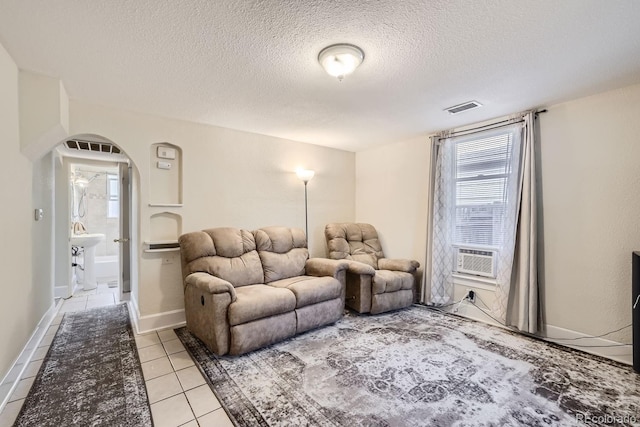 tiled living room with cooling unit and a textured ceiling