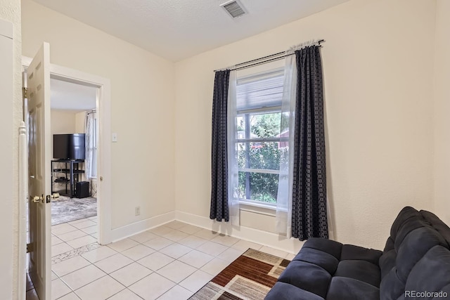 living room with a textured ceiling and light tile patterned floors