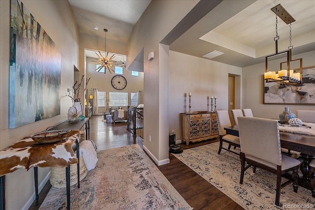 12590 Valentia St, Thornton, CO 80602 - dining area featuring a chandelier, wood finished floors, baseboards, and a high ceiling