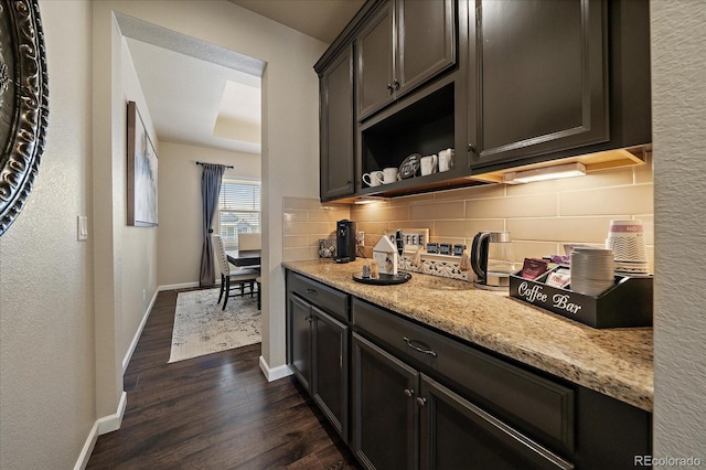 12590 Valentia St, Thornton, CO 80602 - kitchen featuring dark wood-type flooring, tasteful backsplash, baseboards, light stone countertops, and open shelves