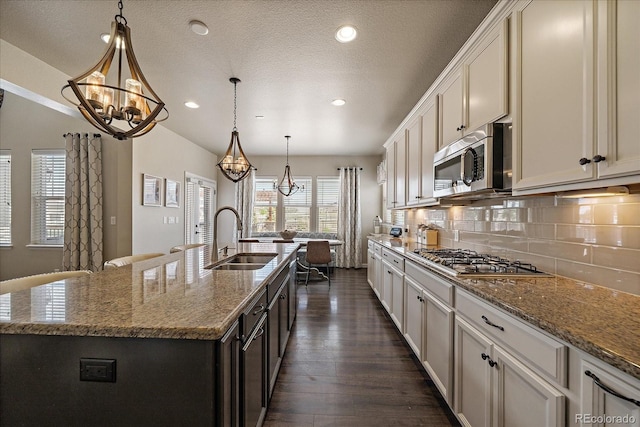 12590 Valentia St, Thornton, CO 80602 - kitchen featuring a chandelier, a sink, appliances with stainless steel finishes, an island with sink, and recessed lighting