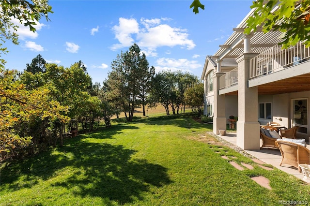 view of yard featuring a patio and a balcony