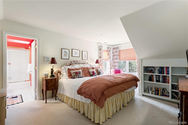 bedroom featuring connected bathroom, light carpet, and lofted ceiling