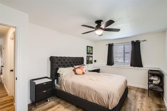 bedroom featuring baseboards, a ceiling fan, and wood finished floors