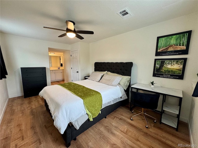 10785 W 63rd Pl Unit 108, Arvada, CO 80004 - bedroom featuring wood finished floors, baseboards, ceiling fan, and ensuite bathroom