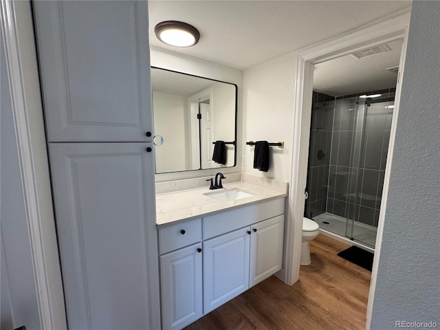 10785 W 63rd Pl Unit 108, Arvada, CO 80004 - full bathroom with toilet, wood finished floors, vanity, and a stall shower