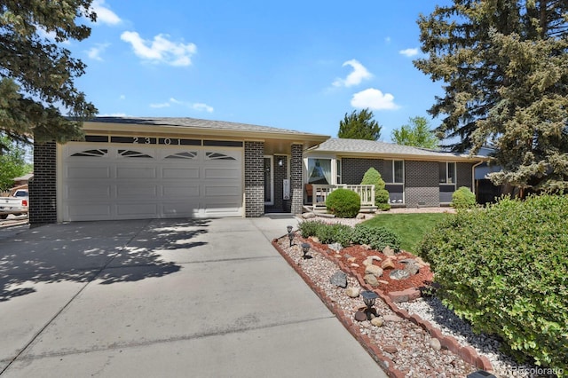 single story home featuring concrete driveway, brick siding, and an attached garage