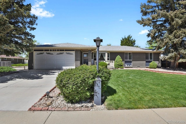 ranch-style house featuring brick siding, a front yard, a garage, and driveway