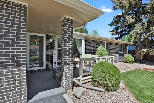 entrance to property with fence and brick siding