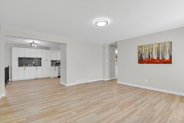 unfurnished living room featuring light wood-style floors and baseboards