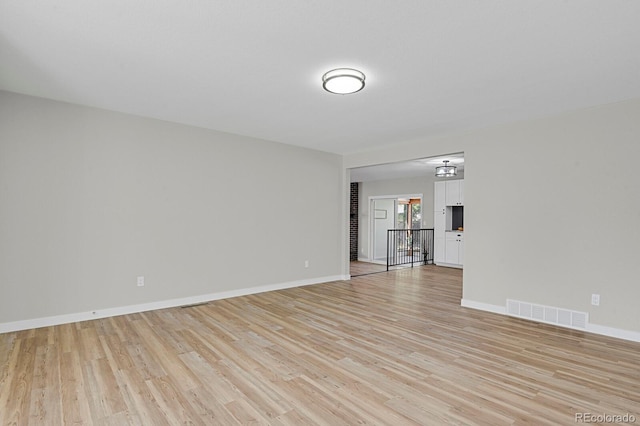 unfurnished living room featuring light wood finished floors and baseboards