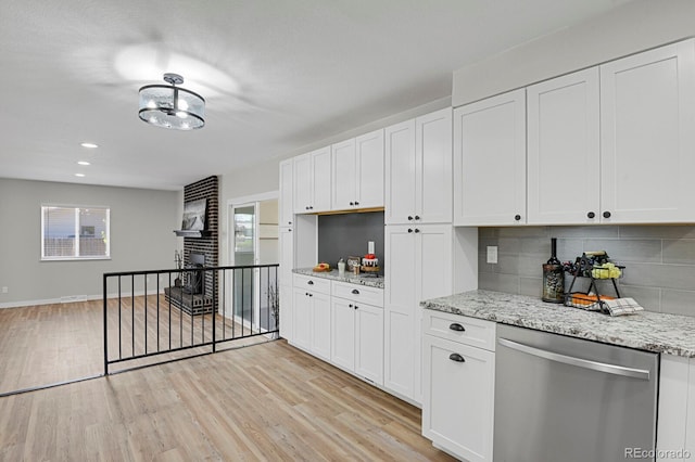 kitchen featuring stainless steel dishwasher, decorative backsplash, light wood finished floors, white cabinetry, and light stone countertops