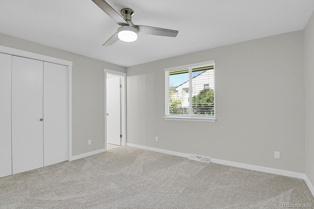 unfurnished bedroom with light carpet, baseboards, a closet, and ceiling fan