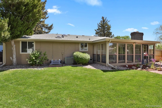 back of property with a chimney, a sunroom, stucco siding, and central AC