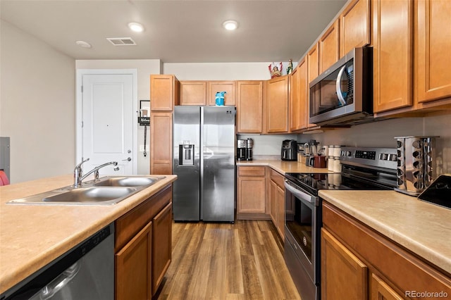 kitchen with sink, hardwood / wood-style floors, and stainless steel appliances