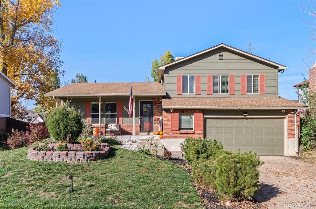 tri-level home featuring a front lawn, a porch, and a garage