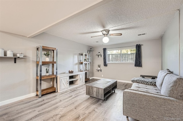 living room with ceiling fan, hardwood / wood-style floors, and a textured ceiling