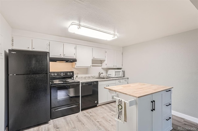 kitchen featuring sink, white cabinetry, wooden counters, a kitchen island, and black appliances