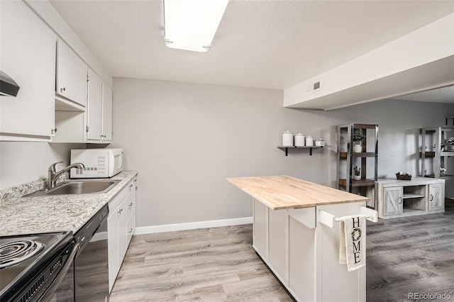 kitchen featuring white cabinets, wooden counters, black appliances, and light wood-type flooring