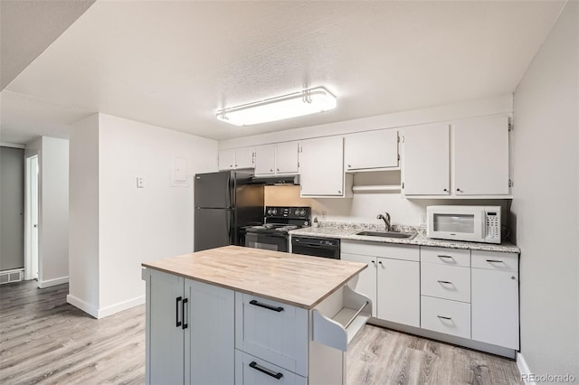 kitchen with black appliances, light hardwood / wood-style flooring, a textured ceiling, and sink