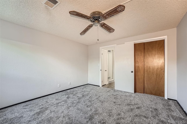 unfurnished bedroom featuring a closet, a textured ceiling, ceiling fan, and carpet flooring