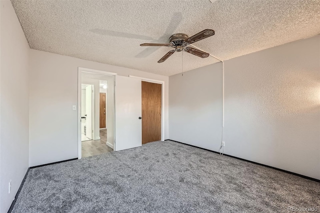 unfurnished bedroom with ceiling fan, light colored carpet, and a textured ceiling