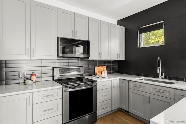 1457 Yates St, Denver, CO 80204 - kitchen with stainless steel electric range oven, light countertops, gray cabinetry, backsplash, and dark wood-style floors
