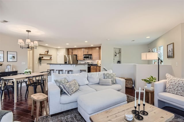 living room featuring dark wood-type flooring and a notable chandelier